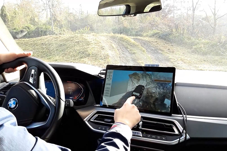 Driver using a laptop for vehicle testing inside a BMW car