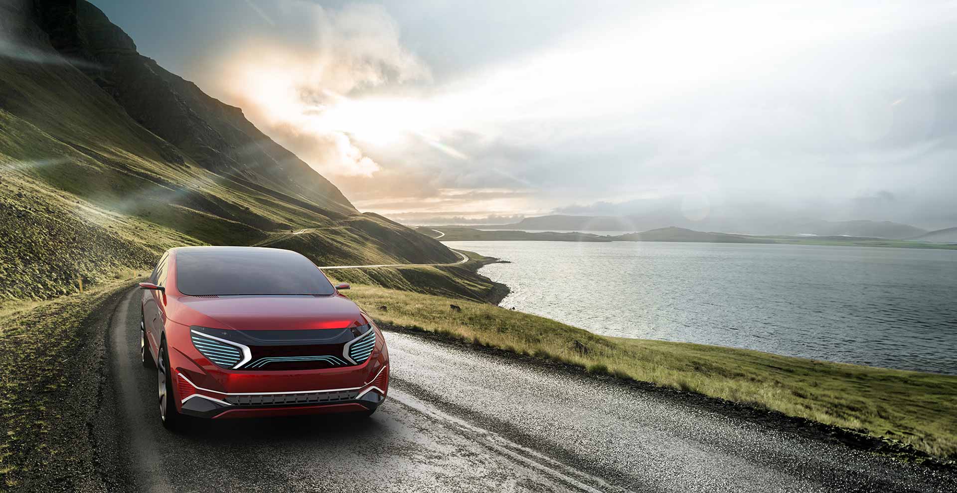 Two lane highway through the desert with a mountain range in the horizon and the sun is setting