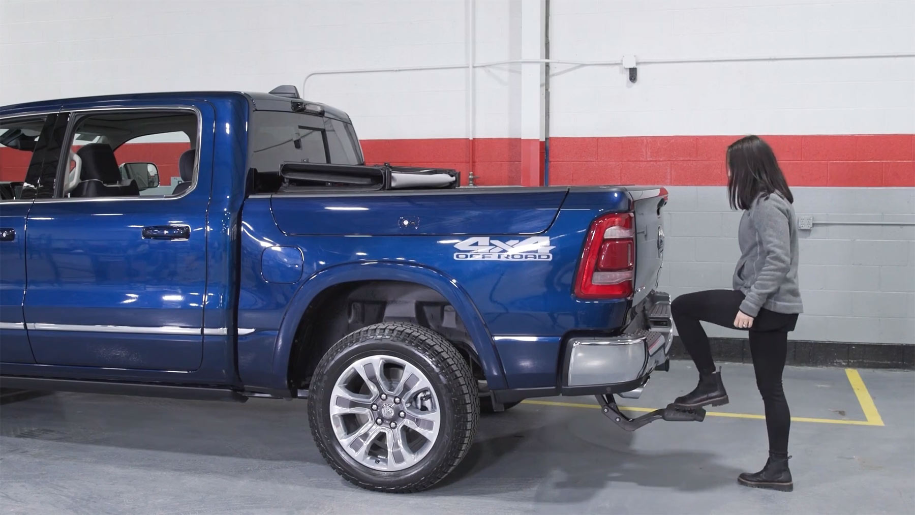 Person standing behind a pick up truck using the box step to get into the truck bed
